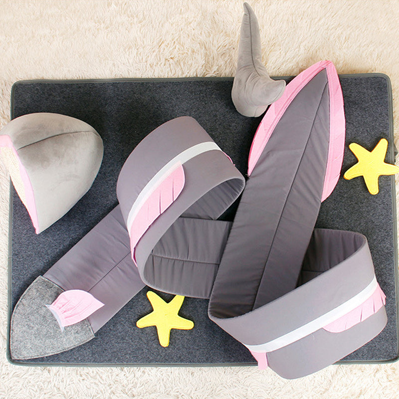 Plush shark tail blanket on a soft gray mat with yellow starfish toys, featuring pink and gray colors, perfect for cozy home decor and kids' play.