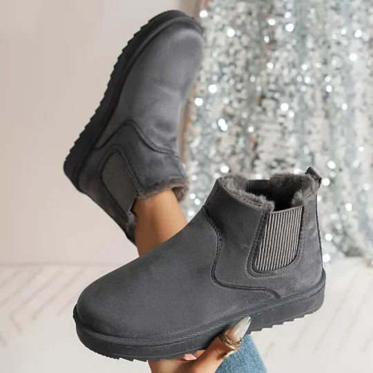 Gray suede ankle boots with faux fur lining, elastic side panels, and rubber soles, perfect for winter fashion and comfort.