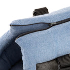 Close-up of a blue canvas backpack with a black zipper, highlighting durable fabric and stitching. Ideal for travel, school, or outdoor activities.