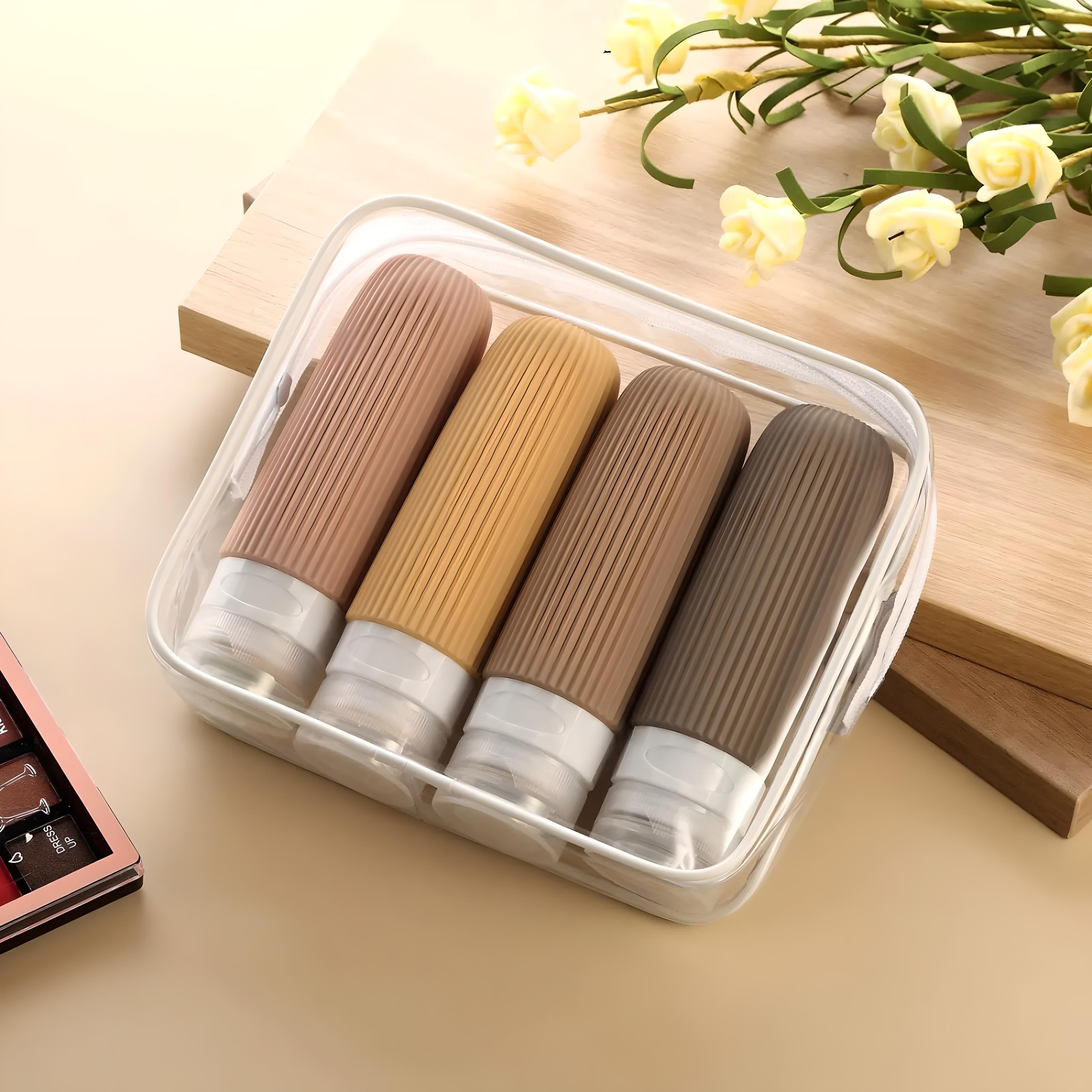 Travel-size silicone bottles in a clear case, ideal for toiletries. Features four leak-proof, squeezable containers in neutral colors. Perfect for travel essentials.