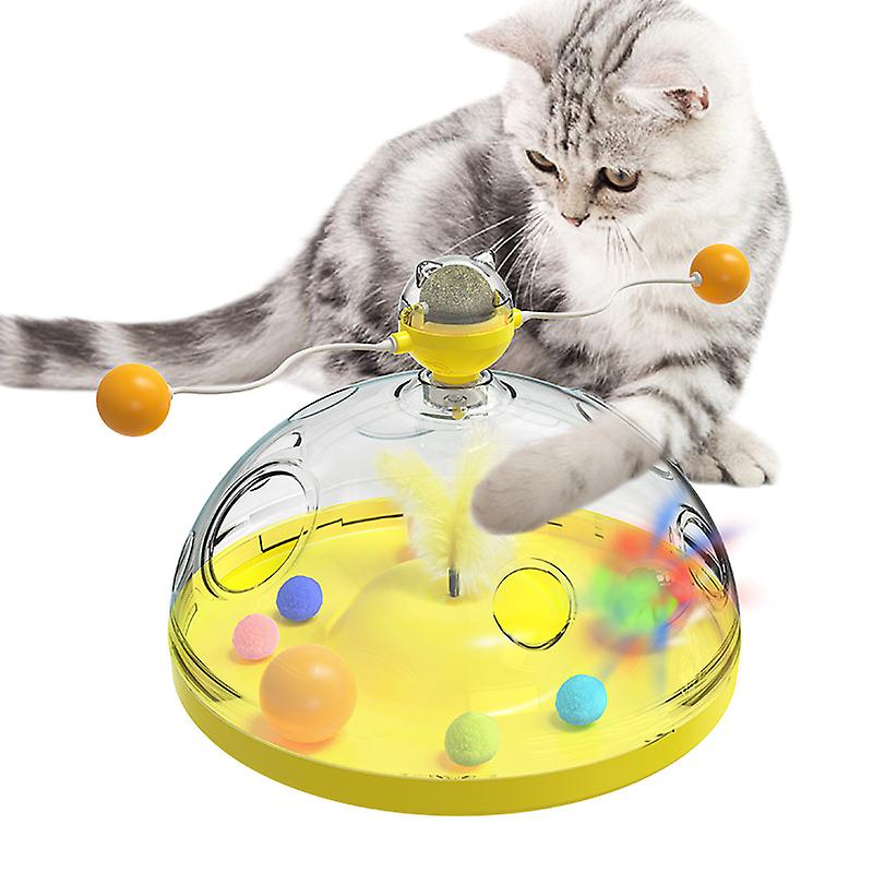 Cat playing with interactive toy dome featuring colorful balls and feathers, designed for pet entertainment and mental stimulation.