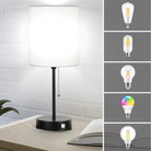 Modern table lamp with white fabric shade on a wooden desk, featuring a black metal base and pull chain. Includes four LED bulb options for versatile lighting.