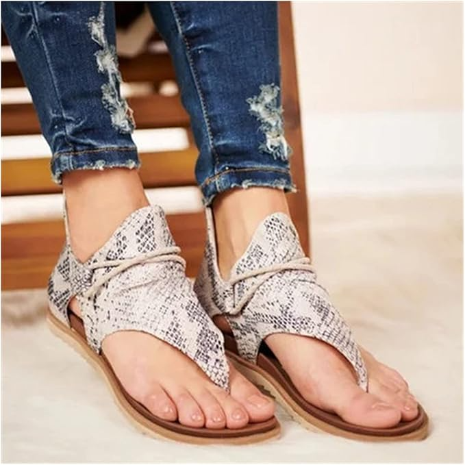 Women's snake print sandals with open toe design, paired with distressed denim jeans. Stylish summer footwear, casual fashion, comfortable fit.