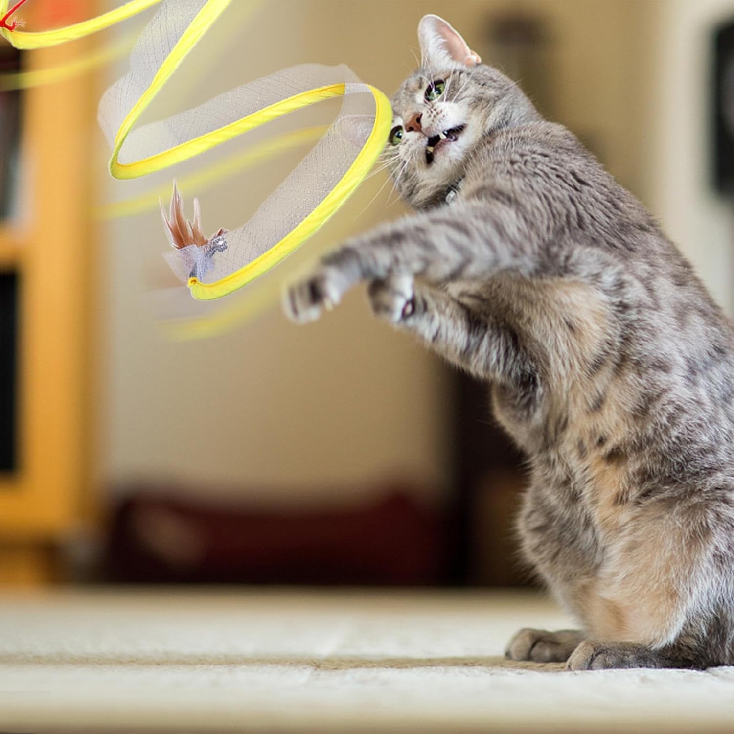 Cat playing with interactive feather toy, showcasing playful behavior indoors. Perfect for pet lovers seeking engaging cat toys.