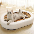 Cat lounging on a cozy, oval-shaped pet bed with a woven center, placed on a sunlit wooden floor. Perfect for pet comfort and relaxation.