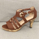 Brown strappy high heel sandal with cork sole, featuring gold buckle accents, perfect for summer fashion and casual wear. Women's footwear.