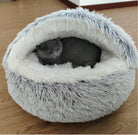 Gray cat nestled in a fluffy, round, shark-shaped pet bed on wooden floor; cozy cat furniture, plush pet bed, comfortable cat sleeping area.