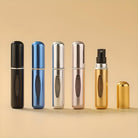 Set of five sleek travel perfume atomizers in black, blue, silver, rose gold, and gold on a beige background, showcasing portable fragrance solutions.