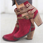 Red suede ankle boots with chunky wooden heels, featuring braided leather straps and metal buckles. Stylish women's footwear, perfect for fall fashion.