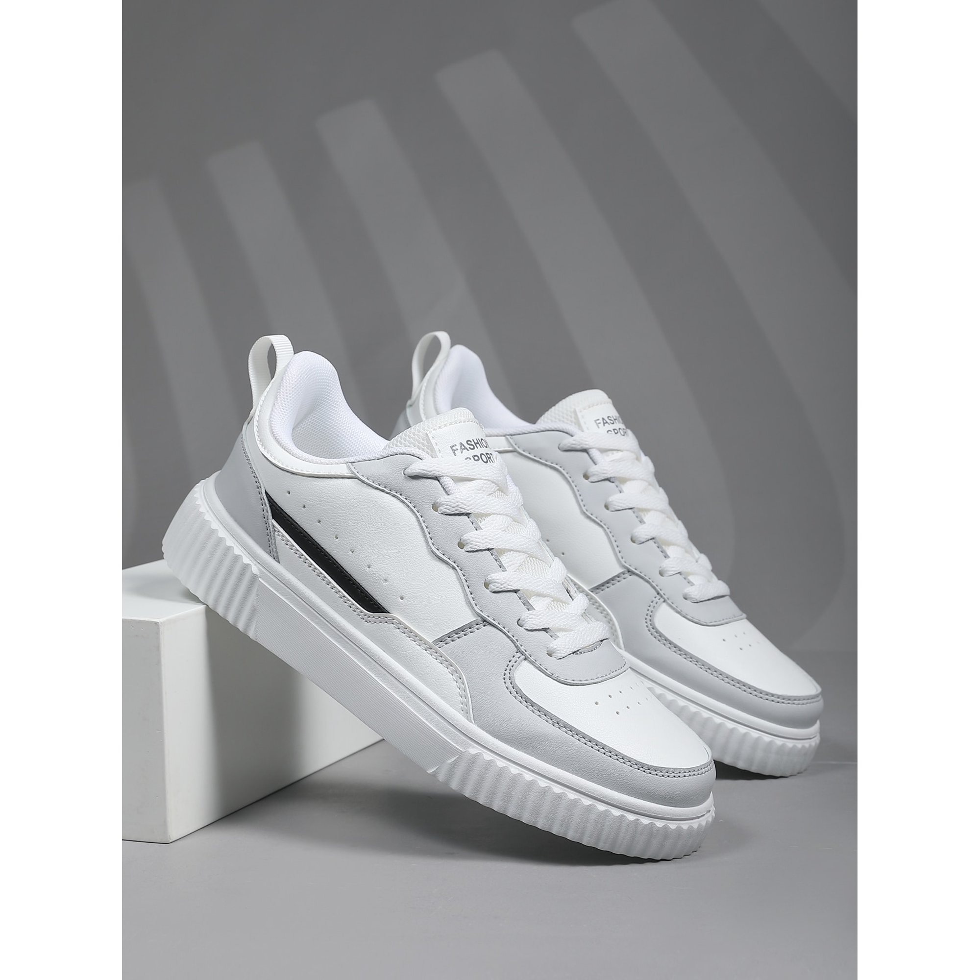 White and gray athletic sneakers with textured soles, featuring a modern design. Perfect for casual wear or sports. High-quality footwear.