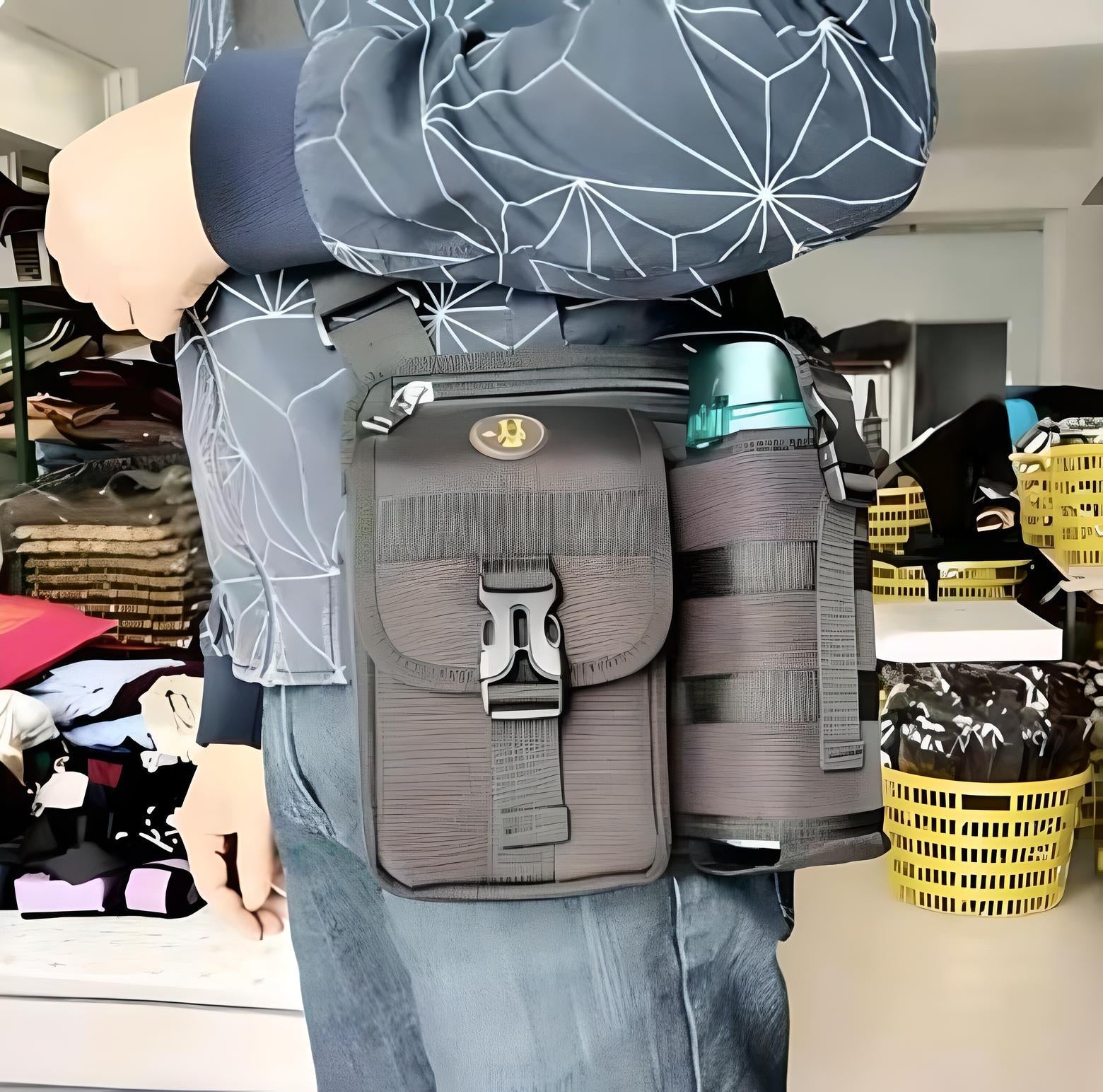 Man wearing a tactical shoulder bag with a water bottle holder, featuring durable black fabric and secure buckle closure, ideal for outdoor activities.