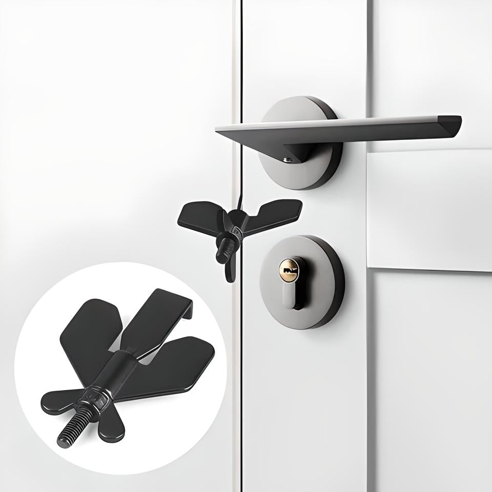 Black butterfly-shaped door lock stopper on a white door with modern handle and keyhole, home security accessory, child safety lock, door stopper.