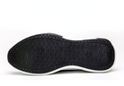 Black sneaker sole with textured grip pattern, white edge, and durable rubber material. Ideal for athletic footwear, offering traction and stability.