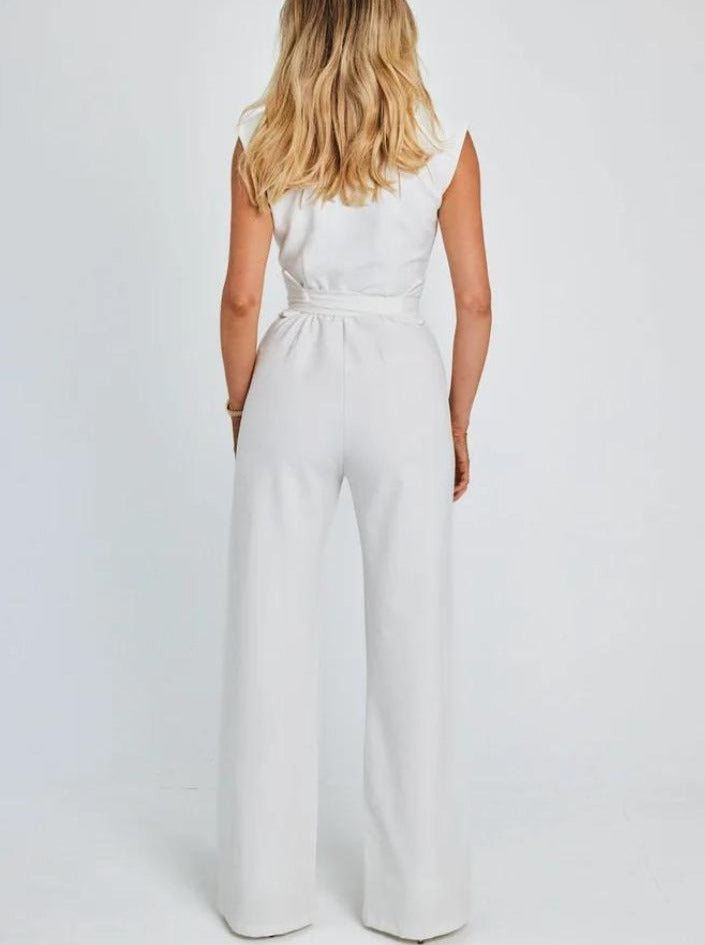 Woman in elegant white sleeveless jumpsuit, back view, showcasing wide-leg design. Perfect for fashion, women's clothing, and style inspiration.