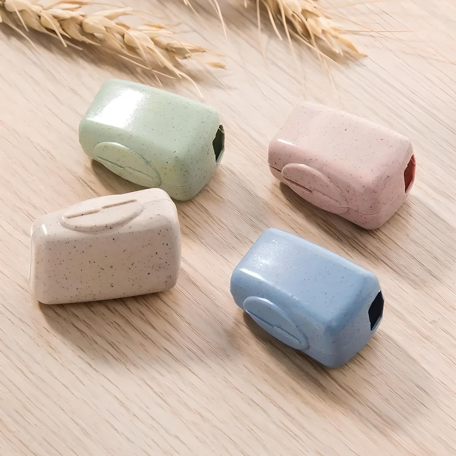 Four pastel-colored, eco-friendly wheat straw soap holders on a wooden surface, featuring green, pink, beige, and blue options for sustainable bathroom storage.