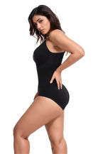Woman modeling black one-piece swimsuit, side view. Fashionable swimwear, sleek design, perfect for summer beachwear. High-quality fabric, elegant fit.
