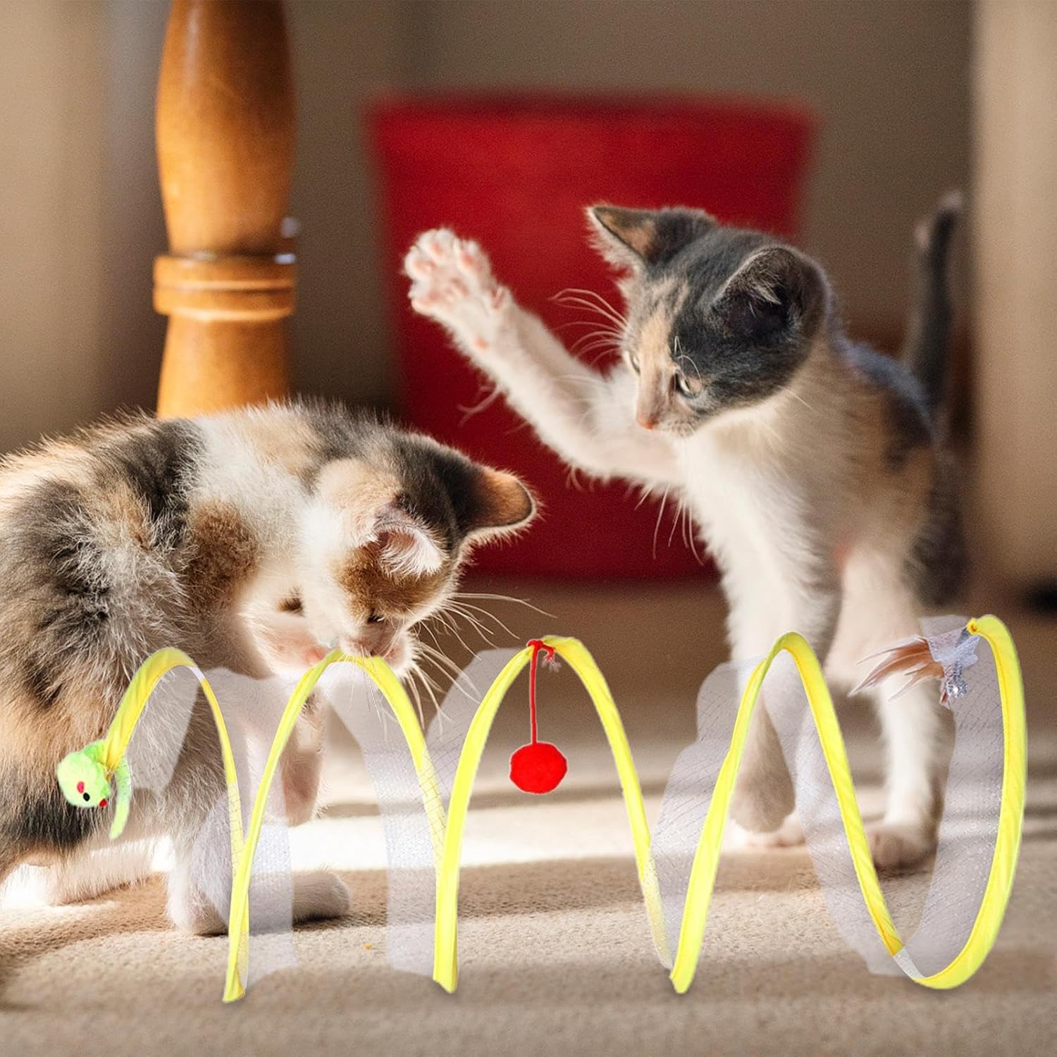 Two playful kittens interact with a yellow spring cat toy featuring a red pom-pom and green mouse, perfect for indoor pet entertainment and exercise.