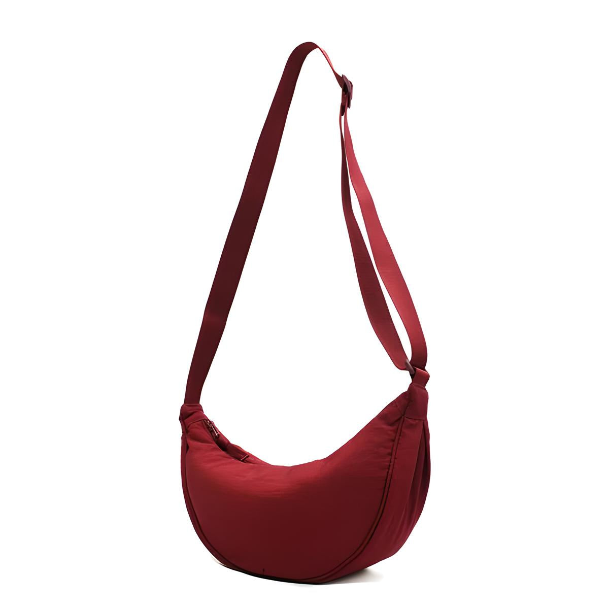 Red crescent-shaped crossbody bag with adjustable strap, minimalist design, perfect for casual outings. Fashionable women's accessory.