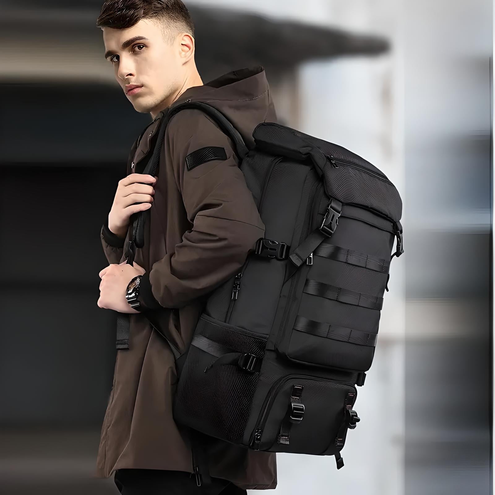 Man wearing a large tactical backpack, dressed in a brown jacket, standing outdoors. Ideal for hiking, travel, and outdoor adventures.