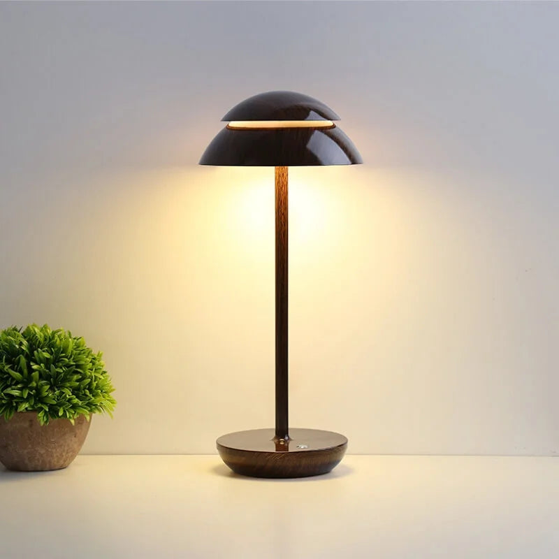 Modern black table lamp with dome shade illuminating a minimalist room, next to a small green plant. Ideal for contemporary home decor lighting.