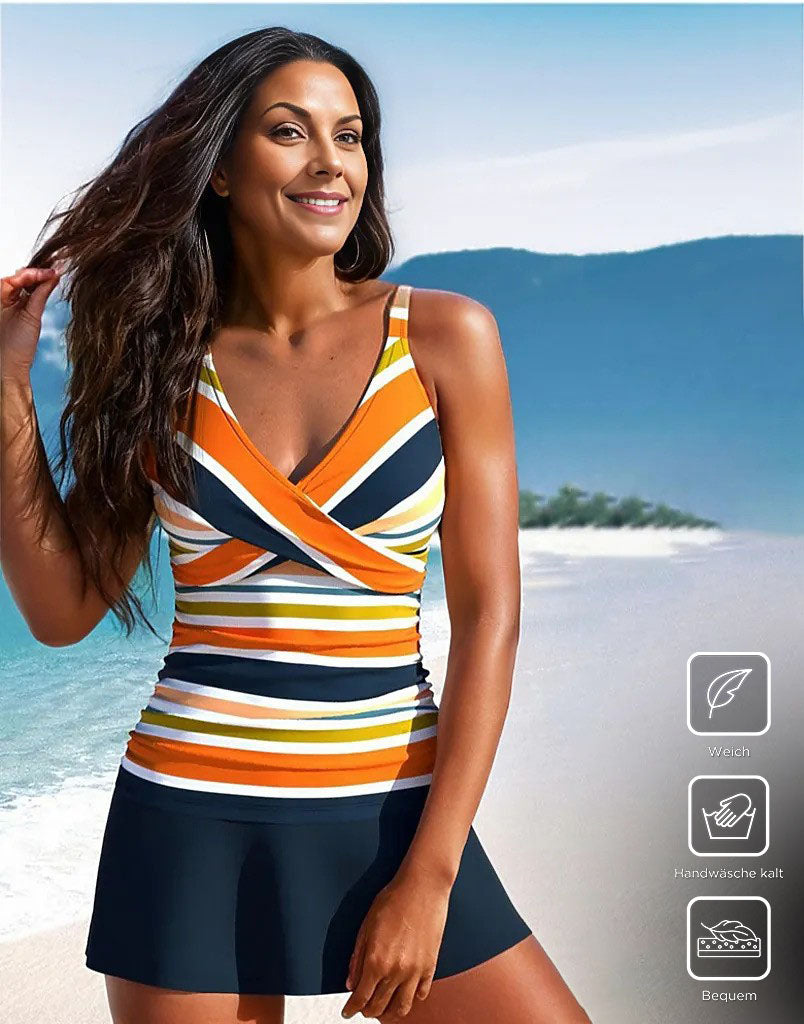 Woman in colorful striped tankini swimsuit on beach; features soft fabric, hand wash cold, comfortable fit. Summer swimwear fashion.