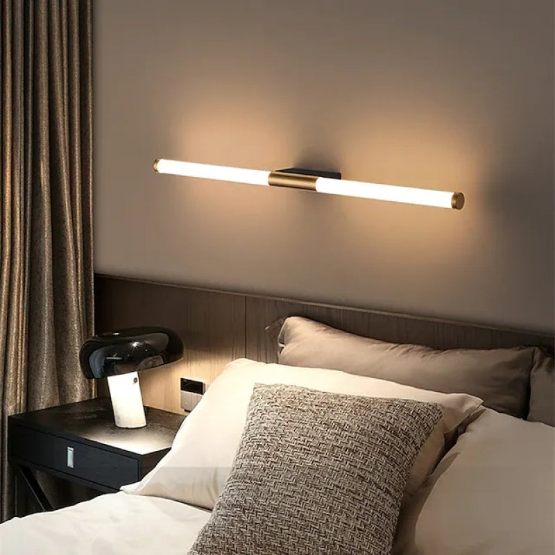 Modern bedroom with sleek wall-mounted LED light fixture above bed, stylish black nightstand, and cozy pillows. Elegant interior lighting design.