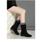 Black mid-calf snow boots with faux fur trim, side zipper, and wedge heel. Stylish winter footwear for women, perfect for cold weather fashion.