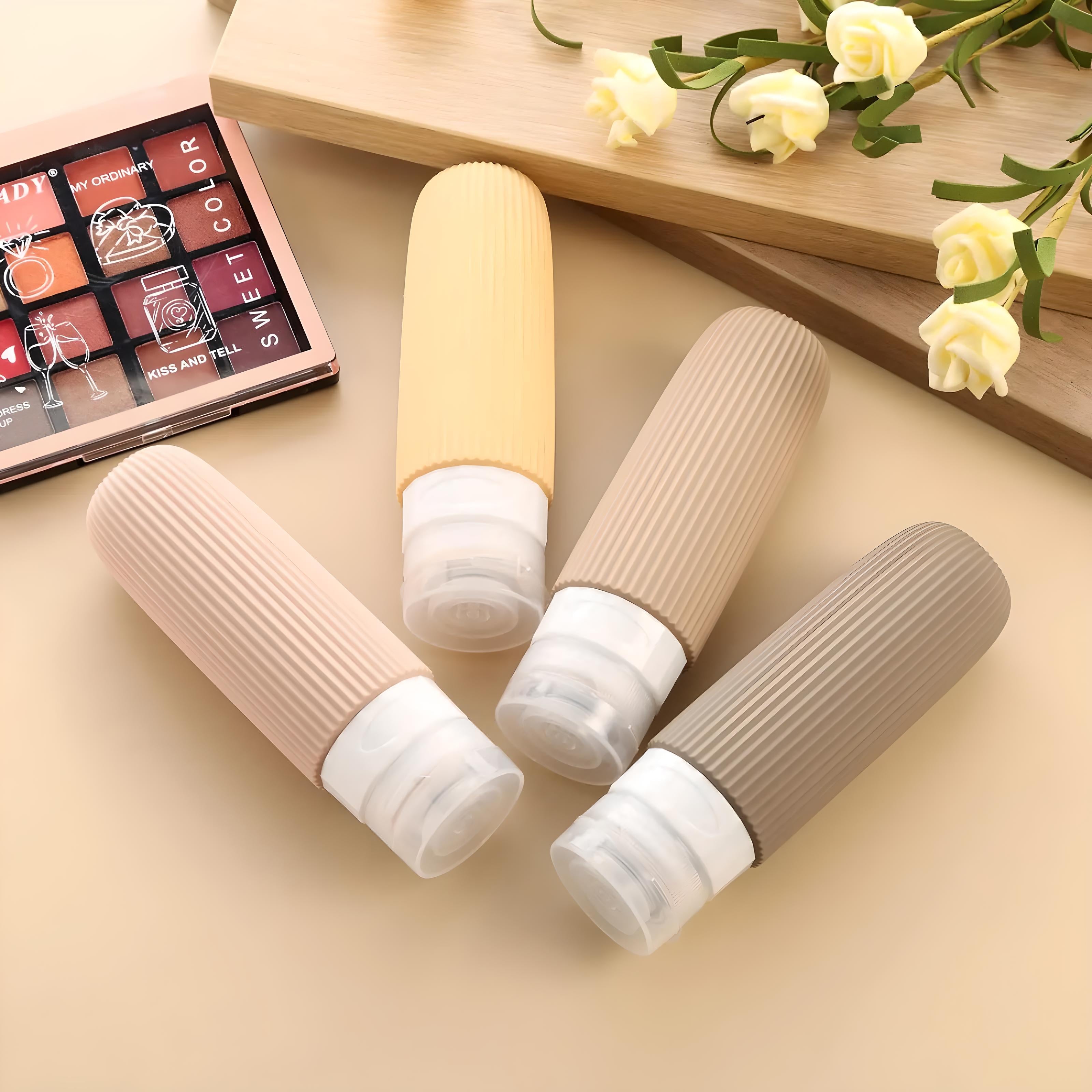 Set of four silicone travel bottles in pastel colors on a beige background, ideal for toiletries. Eco-friendly, leak-proof design for convenient travel.