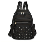 Black leather backpack with quilted front pocket, silver studs, and multiple zippered compartments. Stylish, durable, and perfect for travel or daily use.