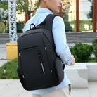 Man wearing a sleek black anti-theft backpack, standing outdoors. Modern design, ideal for travel and daily use. Secure, stylish, and functional.