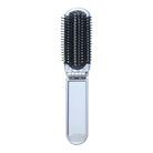 Folding hairbrush with black bristles and silver handle, compact travel design, portable grooming tool, ideal for on-the-go hair care.