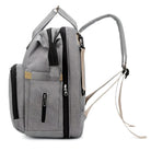 Gray multifunctional diaper backpack with multiple zippered compartments, adjustable straps, and side pockets. Ideal for travel and baby essentials.