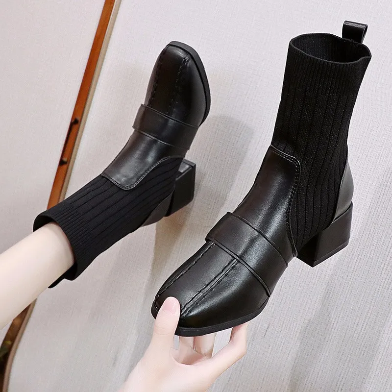 Black leather ankle boots with ribbed knit sock design, block heels, and sleek stitching. Stylish women's footwear for fall fashion trends.