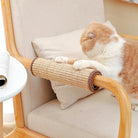 Cat using a woven sisal scratching post on a wooden chair armrest, enhancing home decor while protecting furniture. Ideal for pet-friendly interiors.