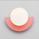 Modern minimalist wall lamp with a circular white light and semi-circular pink base, perfect for contemporary home decor and ambient lighting.