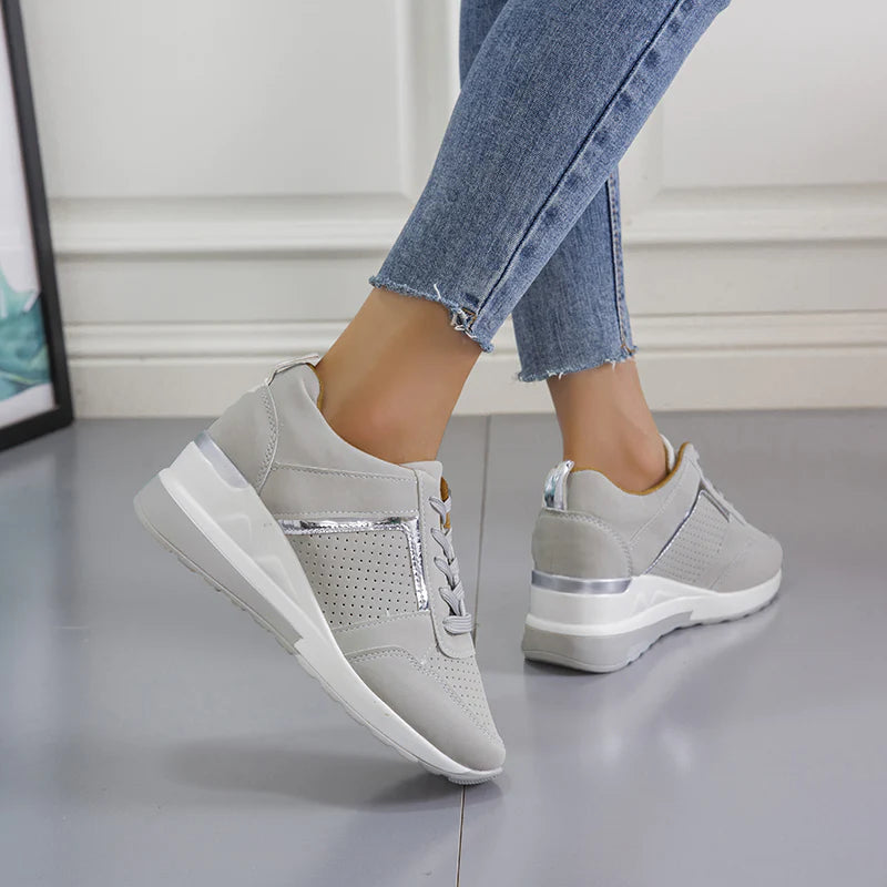 Women's orthopedic sneakers in light gray with silver accents, featuring a comfortable design for pain-free walking. Perfect for casual wear and foot support.