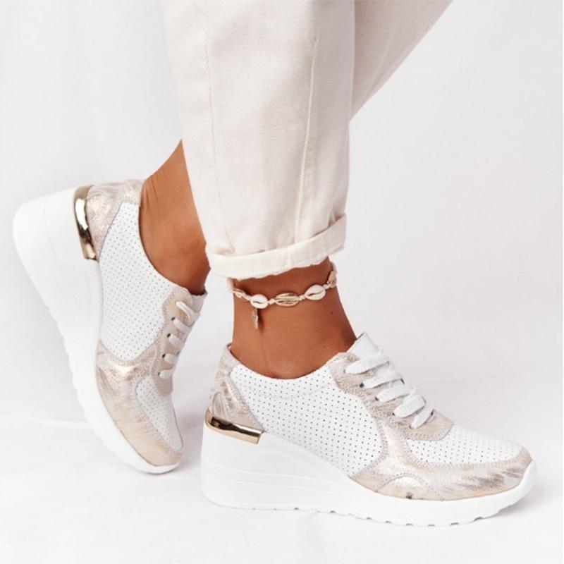 White orthopedic sneakers with gold accents, featuring a wedge heel and perforated design. Stylish and comfortable footwear for pain-free walking.