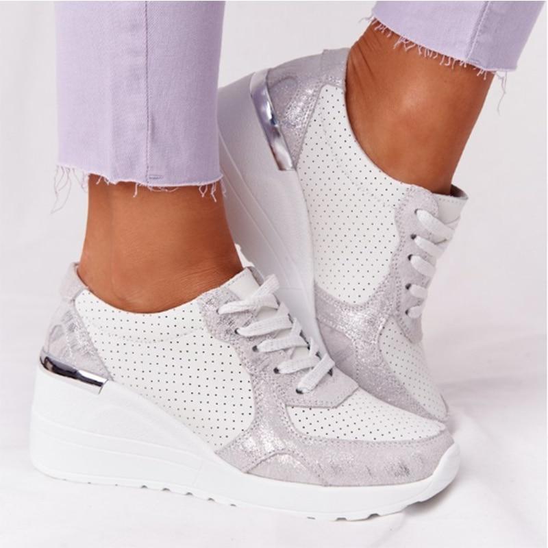 White orthopedic sneakers with silver accents and perforated design, featuring a wedge heel. Ideal for comfort and style. Perfect for pain-free walking.