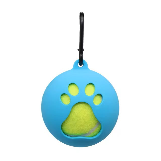 Blue silicone dog ball holder with paw print design, featuring a yellow tennis ball inside. Pet accessory with carabiner clip for easy attachment.