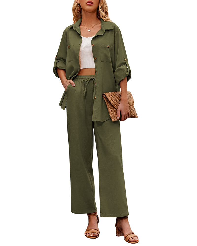 Woman wearing an army green two-piece outfit with a button-up shirt and wide-leg pants, holding a woven clutch, and wearing sandals. Fashionable casual attire.