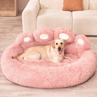 Dog resting on a plush pink paw-shaped pet bed in a cozy living room setting, featuring soft textures and modern decor. Perfect for pet comfort.