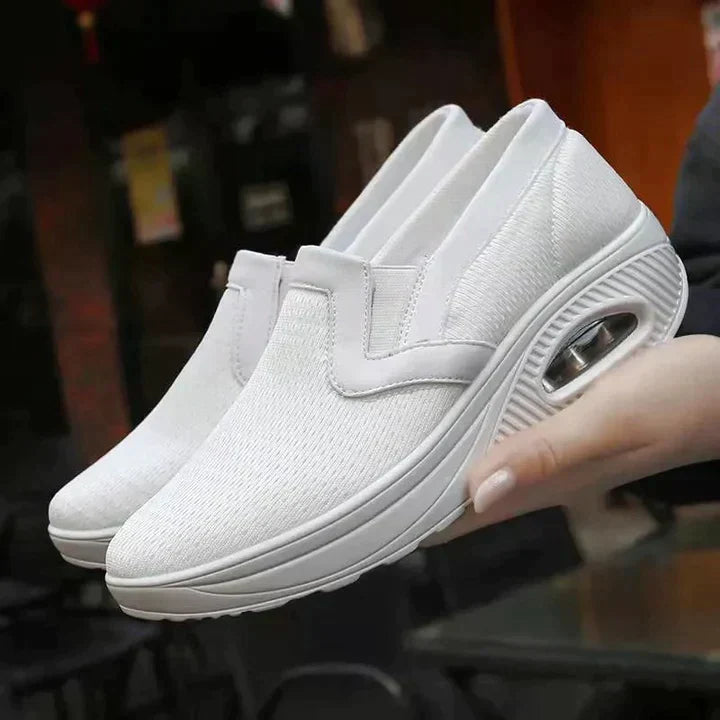 White orthopedic women's sneakers, breathable and comfortable, designed for diabetic foot care, featuring a soft, supportive sole for walking.