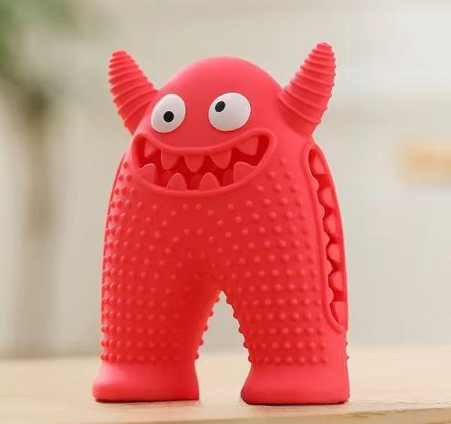 Red monster-shaped dog chew toy with textured surface, durable rubber material, and playful design. Ideal for pet dental health and interactive play.