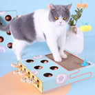 Interactive cat toy with scratching pad, featuring multiple holes and wooden levers, engaging a gray and white cat. Perfect for playful feline entertainment.