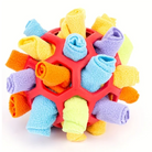 Colorful fleece dog toy with a red hexagonal rubber frame, featuring rolled fabric in blue, yellow, orange, and purple. Durable pet chew ball.