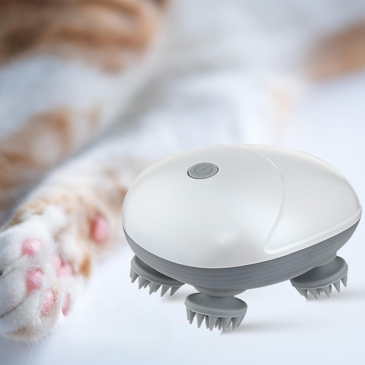 Electric cat massager with rotating bristles, designed for pet relaxation and grooming, placed near a cat's paw. Ideal for stress relief and comfort.