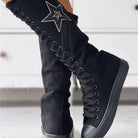 Black knee-high lace-up canvas boots with star embellishment and tassels, featuring a flat rubber sole. Stylish women's footwear for casual wear.