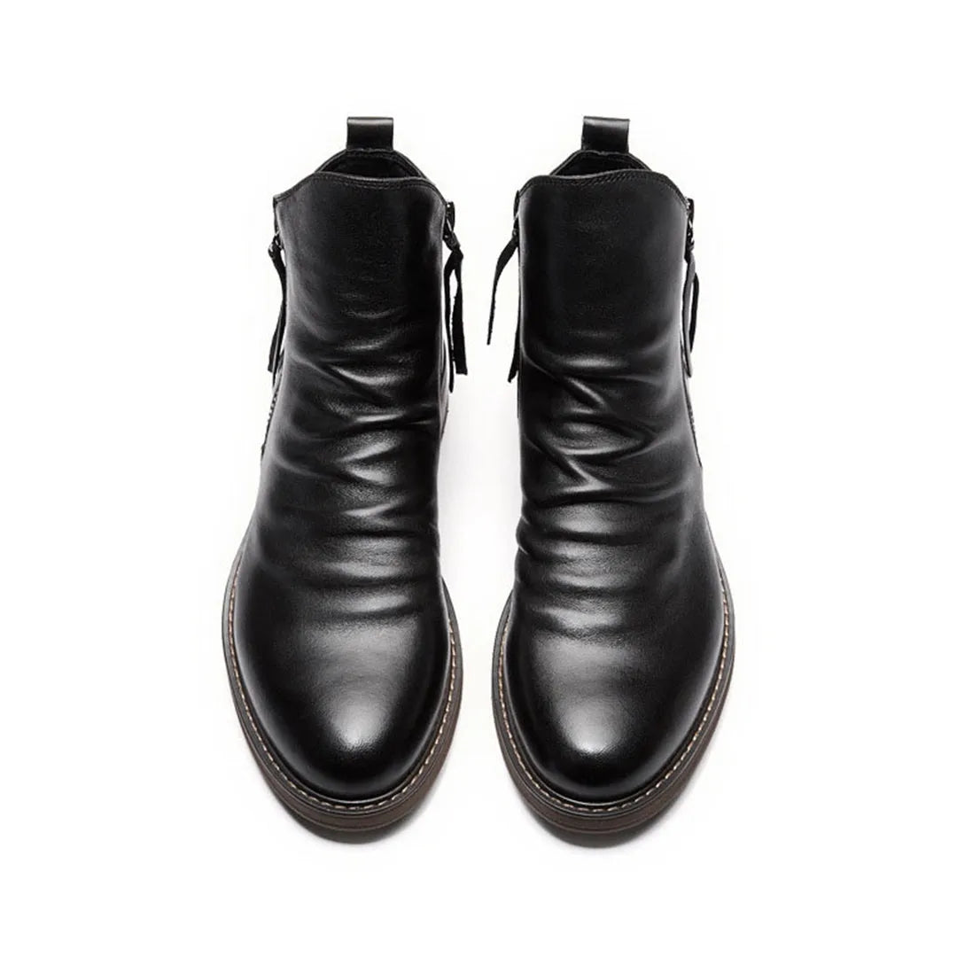 Black leather ankle boots with side zippers, top view. Stylish men's footwear, sleek design, durable sole. Perfect for casual and formal wear.