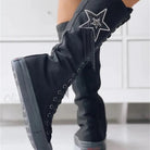 Black knee-high boots with star embellishment, rhinestone details, and lace-up design. Stylish women's footwear, perfect for fashion-forward looks.