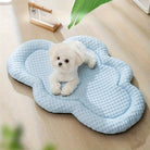 Small white dog on a cloud-shaped cooling mat for pets, light blue color, textured surface, ideal for summer, pet comfort, home decor.